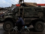 A man rides past an American MaxxPro military vehicle in the formerly Russian occupied city of Lyman, Donetsk region of Ukraine, on December 11. Fierce fighting in the region in recent weeks has left unclear which parts of Donetsk are under Russian and Ukrainian control, Reuters reported.(Shannon Stapleton / REUTERS)