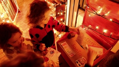 Children put letters in Santa's letter box during their visit to the Haines residence. (REUTERS)
