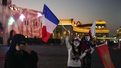 Women hold flags from France, Morocco and Qatar at Katara Cultural Village in Doha, Qatar, Sunday, Dec. 11, 2022. (AP)
