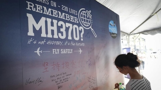 MH370 Disappearance: A girl writes a condolence message during the Day of Remembrance for MH370 event in Kuala Lumpur, Malaysia.(AP Photo)