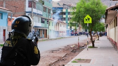 A police officer launches tear gas during clashes with protesters near the airport in Cuzco, as they protest demanding the dissolution of the Congress and to hold democratic elections rather than recognizing Dina Boluarte as Peru's President, after the ouster of Peruvian leader Pedro Castillo. (REUTERS)