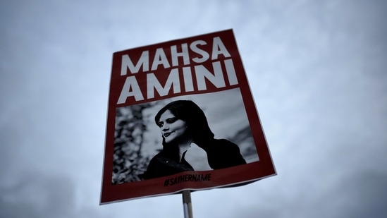 Iran Anti-Hijab Protests: A woman holds a placard with a picture of Iranian woman Mahsa Amini during a protest against her death. (AP)