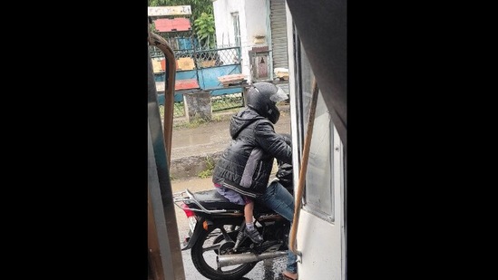 Pic of man protecting a child from rains. (Twitter/@Dr Ajayita )