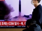 North Korea: A man walks past a TV broadcasting a news report, on North Korea firing a missile.
