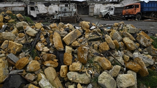 Russia-Ukraine War: Damaged trucks amid debris at a grain storage facility destroyed following missile attack.(AFP)