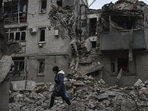 A woman walks past debris of the destroyed house after Russian air strike in Ukraine.