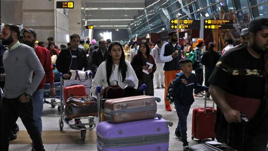 Travellers push carts with their luggage at the departure area of Terminal 3 at Indira Gandhi International Airport in New Delhi. (Reuters)