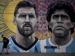 A man passes by a mural depicting Argentine football stars Lionel Messi (L) and late Diego Maradona (R) in the eve of Qatar 2022 World Cup final football match between Argentina and France in Buenos Aires, on December 16, 2022. (Photo by Luis ROBAYO / AFP) A man passes by a mural depicting Argentine football stars Lionel Messi (L) and late Diego Maradona (R) in the eve of Qatar 2022 World Cup final football match between Argentina and France in Buenos Aires, on December 16, 2022. (Photo by Luis ROBAYO / AFP)