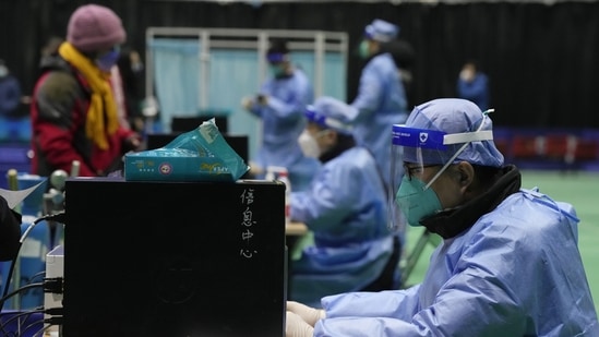 Medical workers attend to visitors at a fever clinic converted from a gymnasium in Beijing, Saturday, December 17, 2022. (AP Photo/Ng Han Guan)