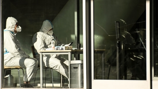 Covid In China: Security guards wearing personal protective equipment (PPE) amid the Covid-19 pandemic sit at an entrance of a building in Beijing.(AFP) Covid In China: Security guards wearing personal protective equipment (PPE) amid the Covid-19 pandemic sit at an entrance of a building in Beijing.(AFP)