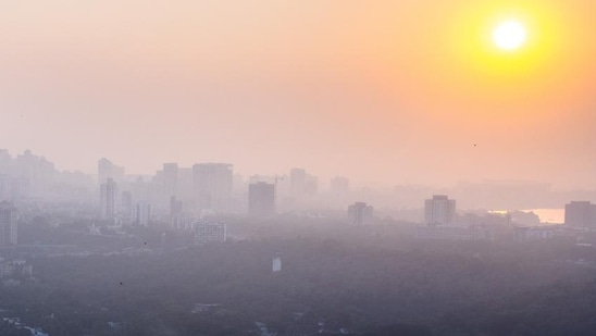 Hazy weather over the skyline as sun sets in the backdrop over Vihar Lake in Mumbai.(HT file)