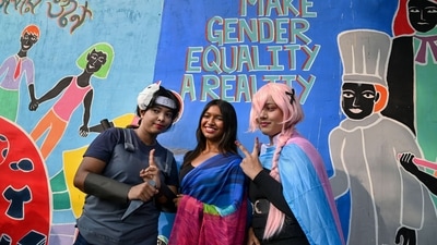 Pride walk supporters posing in front of graffiti promoting gender equality. (PTI) Pride walk supporters posing in front of graffiti promoting gender equality. (PTI)