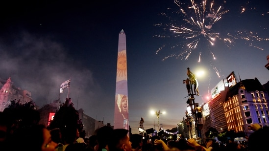 Argentina fans celebrate winning the World Cup at the Obelisk with an image of Lionel Messi and fireworks. Messi and his teammates brought Argentina the most coveted prize in football.(Mariana Nedelcu / REUTERS)