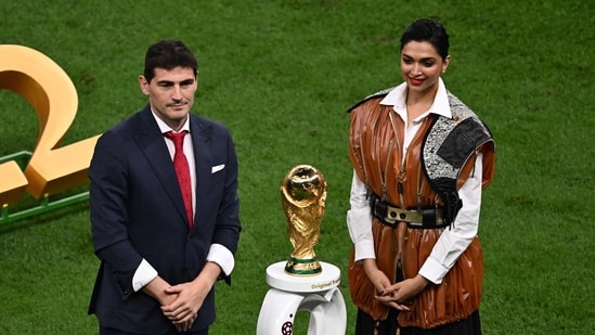 Former Spanish footballer Iker Casillas (left) and actor Deepika Padukone stand next to the World Cup Trophy before the start of the FIFA World Cup final match between Argentina and France at Lusail Stadium in Doha on December 18. (AFP)