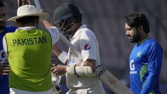 Pakistani players give honor guard to teammate Azhar Ali, center, who is playing his last match due to his retirement, after his dismissal during the third day (AP) Pakistani players give honor guard to teammate Azhar Ali, center, who is playing his last match due to his retirement, after his dismissal during the third day (AP)