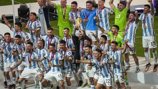 Lionel Messi holds the World Cup trophy with teammates(AP)