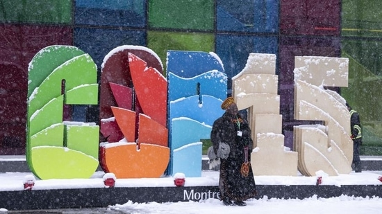 Delegates take souvenir photos during a snowfall outside the convention centre at the COP15 UN conference on biodiversity in Montreal, on Friday. 