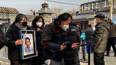 Relatives carry a picture of a loved one at a crematorium in Beijing on December 20. "It's three or four times busier than in previous years, we are cremating over 40 bodies per day when before it was only a dozen or so," a crematorium staffer told AFP. (Noel Celis / AFP) Relatives carry a picture of a loved one at a crematorium in Beijing on December 20. "It's three or four times busier than in previous years, we are cremating over 40 bodies per day when before it was only a dozen or so," a crematorium staffer told AFP. (Noel Celis / AFP)