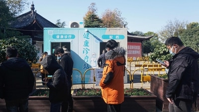 People visit a makeshift clinic transformed from a Covid-19 coronavirus testing booth in Hangzhou, on December 20. In Beijing, local authorities reported just five deaths on December 20 -- up from two the previous day, Reuters reported. (AFP / China OUT) People visit a makeshift clinic transformed from a Covid-19 coronavirus testing booth in Hangzhou, on December 20. In Beijing, local authorities reported just five deaths on December 20 -- up from two the previous day, Reuters reported. (AFP / China OUT)