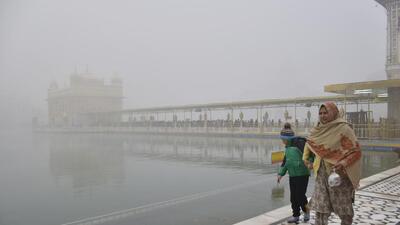 A woman and her grandson at the Golden Temple in Amritsar on a foggy Tuesday morning. (Sameer Sehgal/HT)