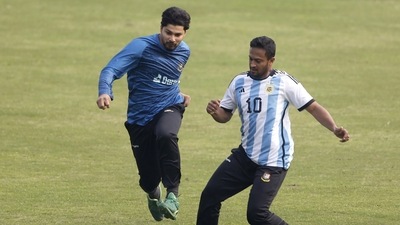 Bangladesh's captain Shakib Al Hasan, right, wearing a jersey of Argentina's football player Lionel Messi, plays football with a teammate during a training session ahead of their second test cricket match against India, in Dhaka, Bangladesh, Tuesday, Dec. 20, 2022. (AP Photo/Surjeet Yadav) (AP)
