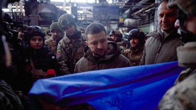 Ukrainian President Volodymyr Zelensky receiving a Ukrainian flag from Bakhmut defenders with their signatures during his visit to the frontline town of Bakhmut. (AFP) Ukrainian President Volodymyr Zelensky receiving a Ukrainian flag from Bakhmut defenders with their signatures during his visit to the frontline town of Bakhmut. (AFP)