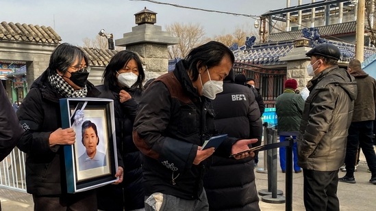 Relatives carry a picture of a loved one at a crematorium in Beijing on December 20. "It's three or four times busier than in previous years, we are cremating over 40 bodies per day when before it was only a dozen or so," a crematorium staffer told AFP.(Noel Celis / AFP)