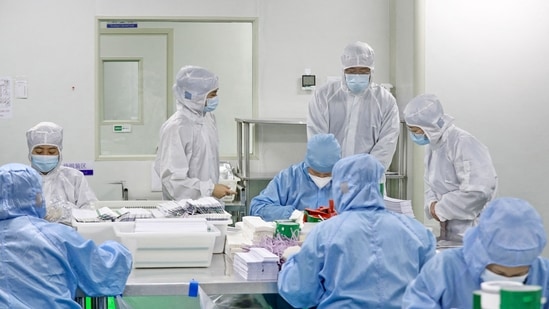 Workers produce antigen test kits to test for Covid-19 infection, at a factory in Nantong, on December 19. Hospitals in China are struggling and pharmacy shelves are stripped bare in the wake of the government's sudden decision to lift years of lockdowns, quarantines and mass testing, AFP reported.(AFP / China OUT)