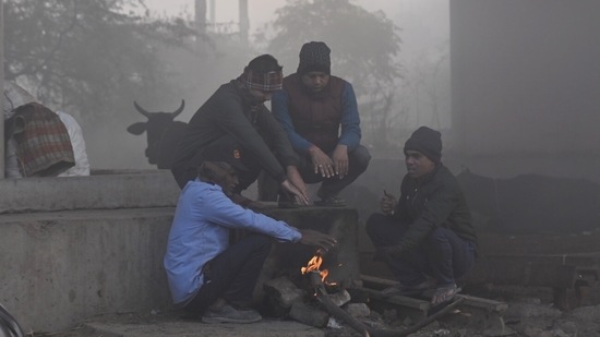 Commuters out on a foggy and cold morning, in Noida.(Sunil Ghosh/HT Photo)