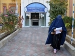 A female university student walks in front of a university gate in Kandahar Province on December 21. Afghanistan's Taliban rulers a day earlier, ordered women nationwide to stop attending private and public universities effective immediately and until further notice. (AFP)