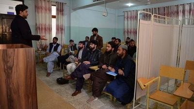 Male university students attend a class bifurcated by a curtain separating males and females at a university in Kandahar Province on December 21. Afghan political analyst Ahmad Saeedi said that the latest decision by the Taliban authorities may have closed the door to winning international acceptance. (AFP) Male university students attend a class bifurcated by a curtain separating males and females at a university in Kandahar Province on December 21. Afghan political analyst Ahmad Saeedi said that the latest decision by the Taliban authorities may have closed the door to winning international acceptance. (AFP)