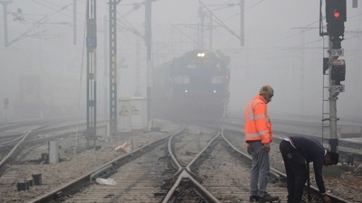 Workers repair a railway track as a train approaches amid low visibility in Amritsar, on December 20. Several trains in Delhi were reported to be running late by a few hours on December 21 due to poor visibility induced by fog. Flight operations remained unaffected, HT reported. (PTI ) Workers repair a railway track as a train approaches amid low visibility in Amritsar, on December 20. Several trains in Delhi were reported to be running late by a few hours on December 21 due to poor visibility induced by fog. Flight operations remained unaffected, HT reported. (PTI )