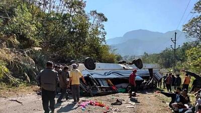 People gather near the wrecked remains of a school bus that overturned while trying to make a sharp turn on the Old Cachar road, in Noney on Wednesday. (ANI) People gather near the wrecked remains of a school bus that overturned while trying to make a sharp turn on the Old Cachar road, in Noney on Wednesday. (ANI)