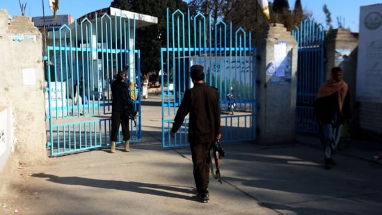 Taliban security personnel stand guard at the entrance gate of a university in Jalalabad on Wednesday. Hundreds of young women were stopped by armed guards on from entering Afghan university campuses, a day after the nation's Taliban rulers banned them from higher education in another assault on human rights, AFP reported.(AFP)