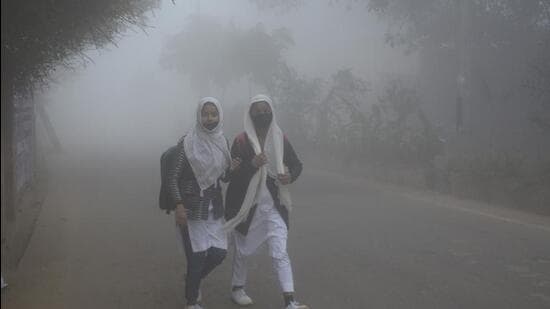 Children going to school amid dense fog at Dasna in Ghaziabad on Monday. (Sakib Ali/HT Photo)
