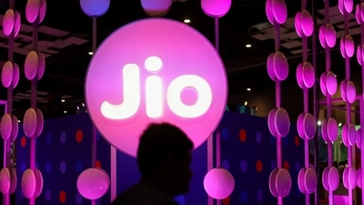 A man walks across the LED board showing the logo of Jio. (REUTERS)