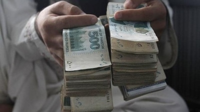 A man holds Pakistani currency bundles. (AP) A man holds Pakistani currency bundles. (AP)