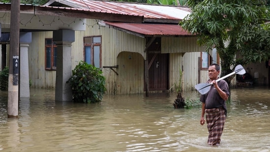 A man is seen walking along a road submerged by floodwaters in Pasir Mas, Kelantan, on December 21. Authorities have set up hundreds of relief shelters as the number of people displaced grows. &nbsp;(AFP )