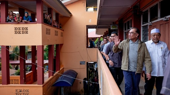 Malaysia's Prime Minister Anwar Ibrahim is seen with flood victims at a relief centre in Pasir Mas, Kelantan, on December 21. Anwar, who is also the finance minister, informed the parliament this week that the government had initially allocated 400 million Malaysian ringgit ($90 million) for the emergency, AFP reported.&nbsp;(Prime Minister's Office of Malaysia / Afiq Hambali/ REUTERS)
