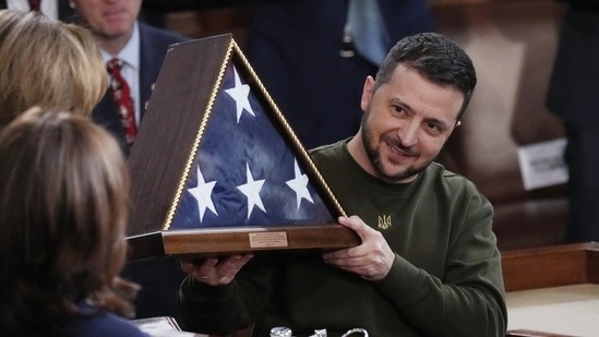 Ukrainian President Volodymyr Zelenskyy holds an American flag that was gifted to him by House Speaker Nancy Pelosi of Calif., after he addressed a joint meeting of Congress on Capitol Hill in Washington, Wednesday, Dec. 21, 2022. House Speaker Nancy Pelosi of Calif., left, and Vice President Kamala Harris, to her right. (AP Photo/J. Scott Applewhite)(AP)