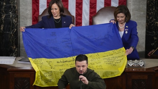 Vice President Kamala Harris and House Speaker Nancy Pelosi of Calif., right, react as Ukrainian President Volodymyr Zelenskyy presents lawmakers with a Ukrainian flag autographed by front-line troops in Bakhmut, in Ukraine's contested Donetsk province, as he addresses a joint meeting of Congress on Capitol Hill in Washington, Wednesday, Dec. 21, 2022. (AP Photo/Jacquelyn Martin)(AP)