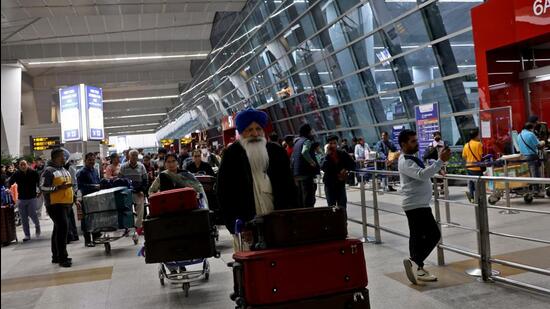 Travellers push trolleys with their luggage at the departure area of the Indira Gandhi International Airport in New Delhi. (REUTERS)