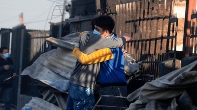 People embrace in the rubble of houses destroyed by the forest fire. (AFP) People embrace in the rubble of houses destroyed by the forest fire. (AFP)