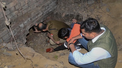 Kanpur: Police personnel inspect the tunnel, allegedly dug and used by thieves to steal gold from the strong room of a branch of State Bank of India, at Bhauti in Kanpur, Friday, Dec. 23, 2022. (PTI Photo) Kanpur: Police personnel inspect the tunnel, allegedly dug and used by thieves to steal gold from the strong room of a branch of State Bank of India, at Bhauti in Kanpur, Friday, Dec. 23, 2022. (PTI Photo)