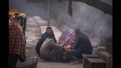 People warm themselves around a fire on Friday morning near Akshardham Temple in New Delhi. (Raj K Raj/HT Photo)