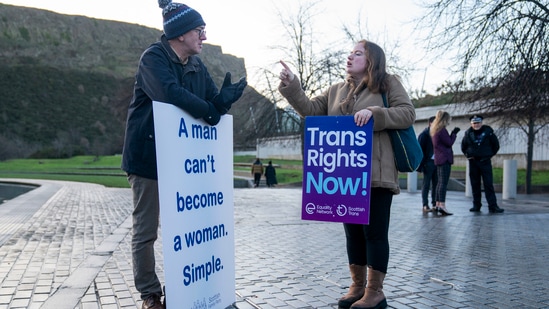A member of the Scottish Family Party, left, speaks with a supporter of the Gender Recognition Reform Bill (Scotland) during a protest outside the Scottish Parliament, ahead of a debate on the bill, in Edinburgh. (Jane Barlow/PA via AP)