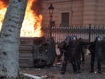 Paris Shooting: Police officers rush past a burning car during a protest. Paris Shooting: Police officers rush past a burning car during a protest.