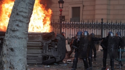 Paris Shooting: Police officers rush past a burning car during a protest. (AP)