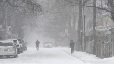 People walk down a residential street during the snowstorm in Canada. (AP) People walk down a residential street during the snowstorm in Canada. (AP)