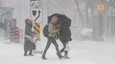 Transit riders face blowing snow after leaving a streetcar stop during a snowstorm in Canada. (AP) Transit riders face blowing snow after leaving a streetcar stop during a snowstorm in Canada. (AP)